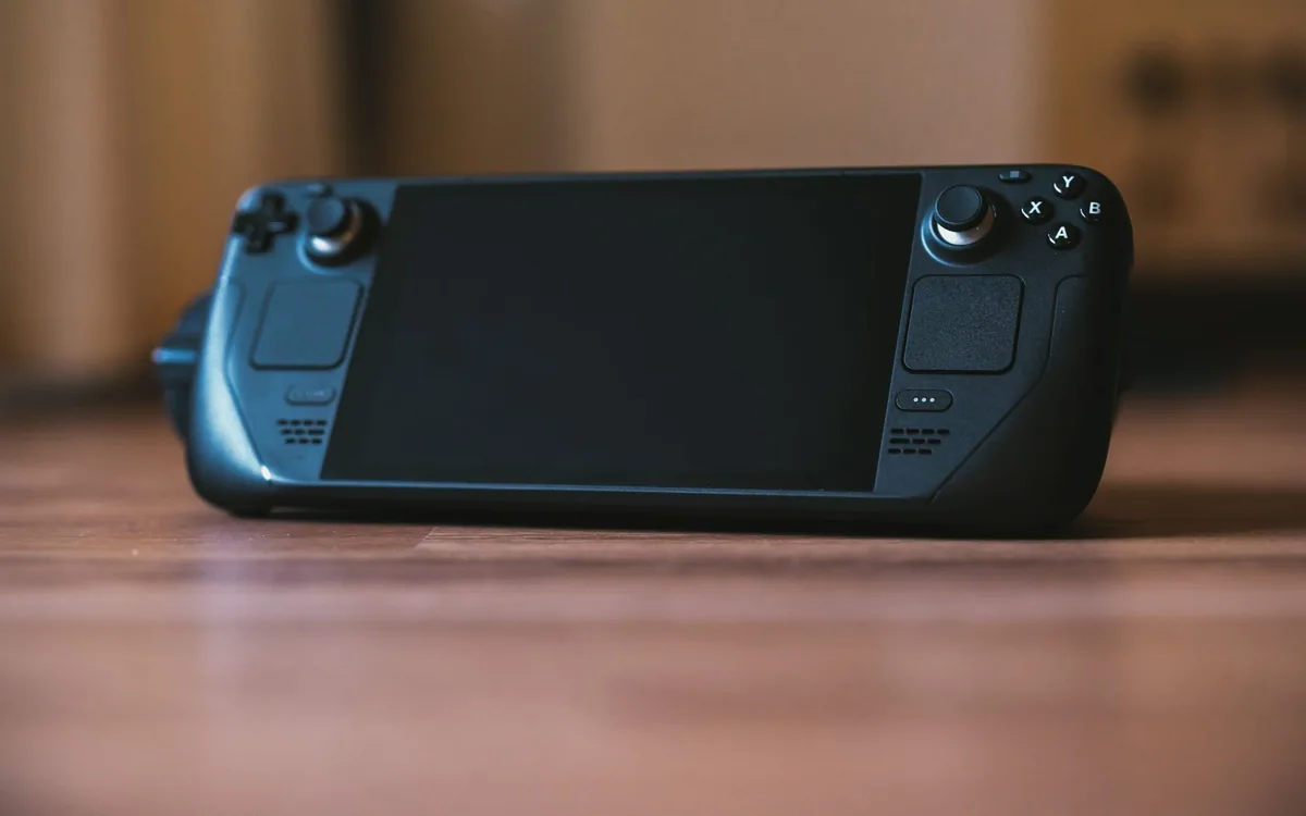 A handheld gaming console on a wooden surface.